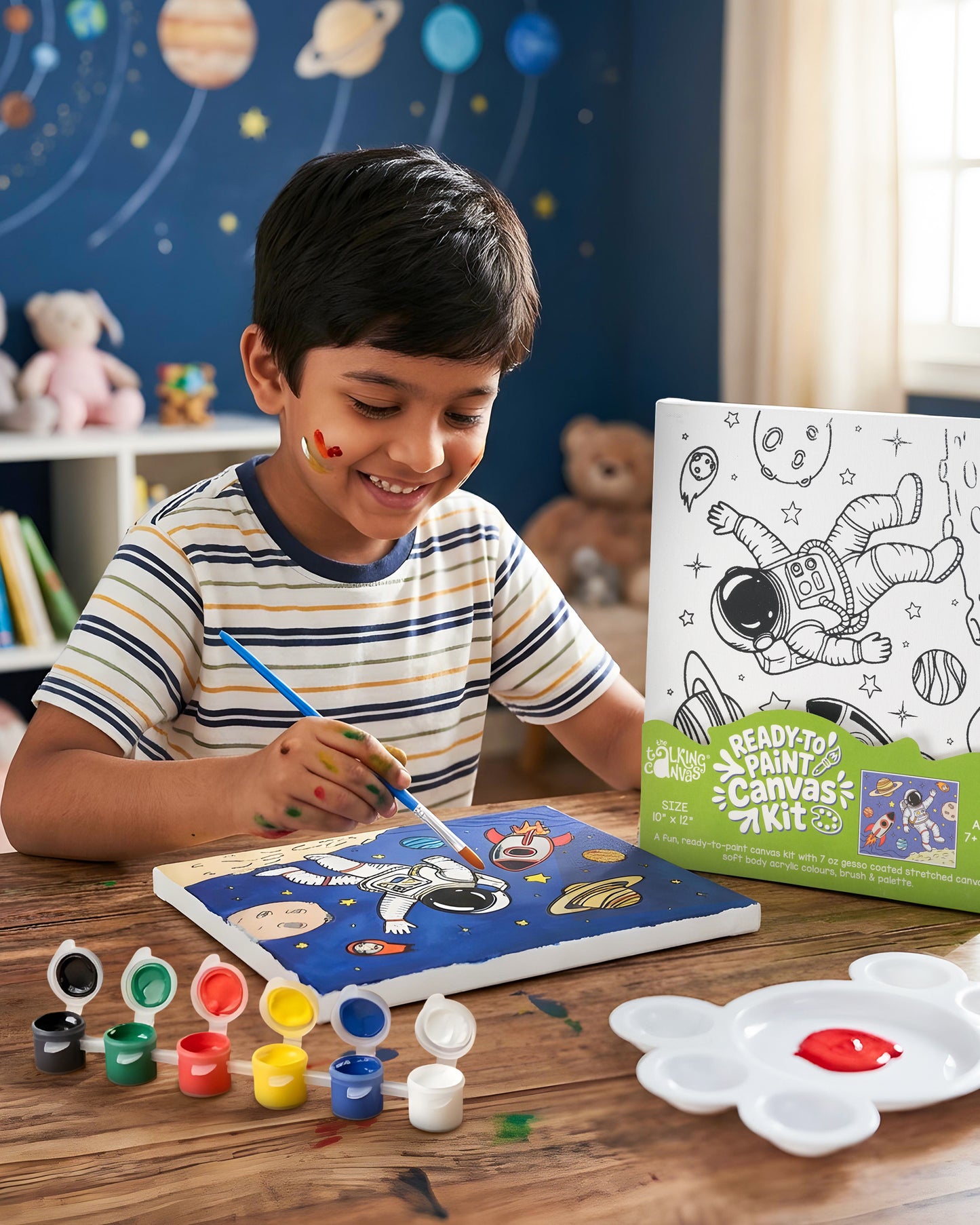 Child painting the Astronaut Ready-to-Paint Canvas Kit featuring a colourful outer space scene with an astronaut, planets and rocket.
