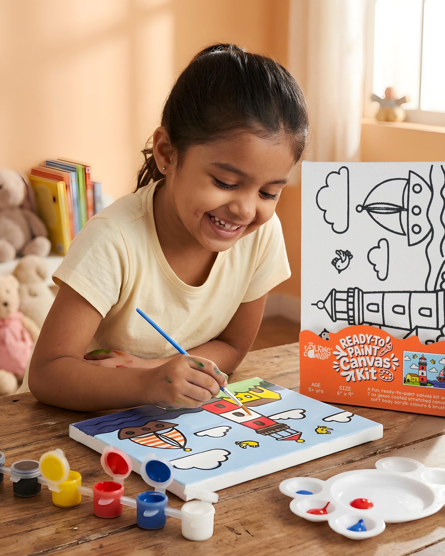 Child painting the Lighthouse Ready-to-Paint Canvas Kit 6×9 using acrylic paints to create a colourful lighthouse and sailboat seaside artwork.