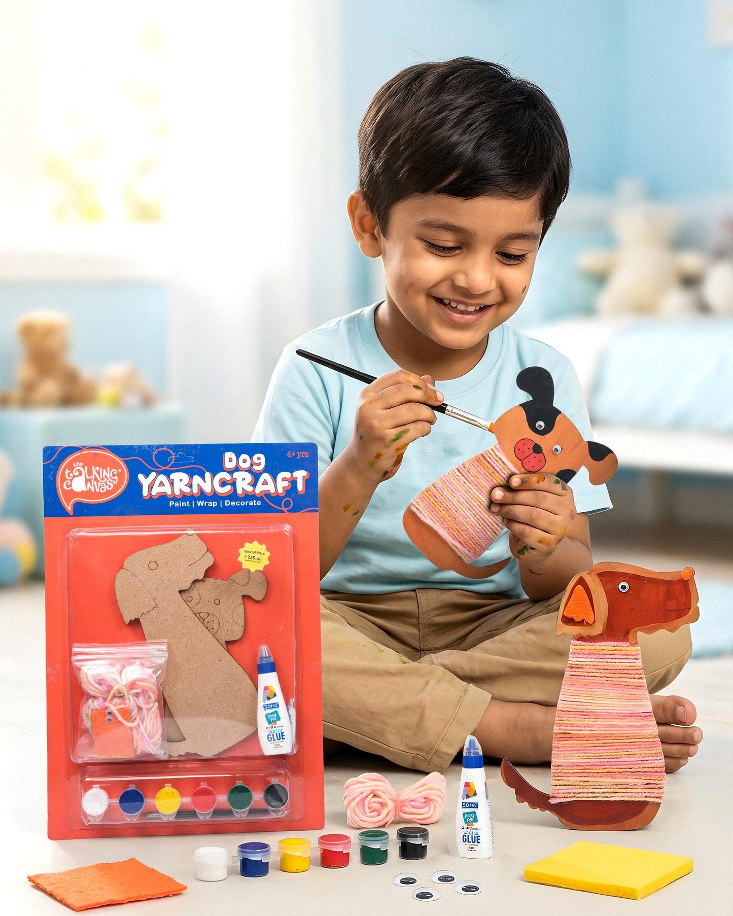 Child creating the Dog Yarn Craft Kit by painting, wrapping yarn around MDF dog cut-outs and decorating them with felt and googly eyes during a fun screen-free craft activity.