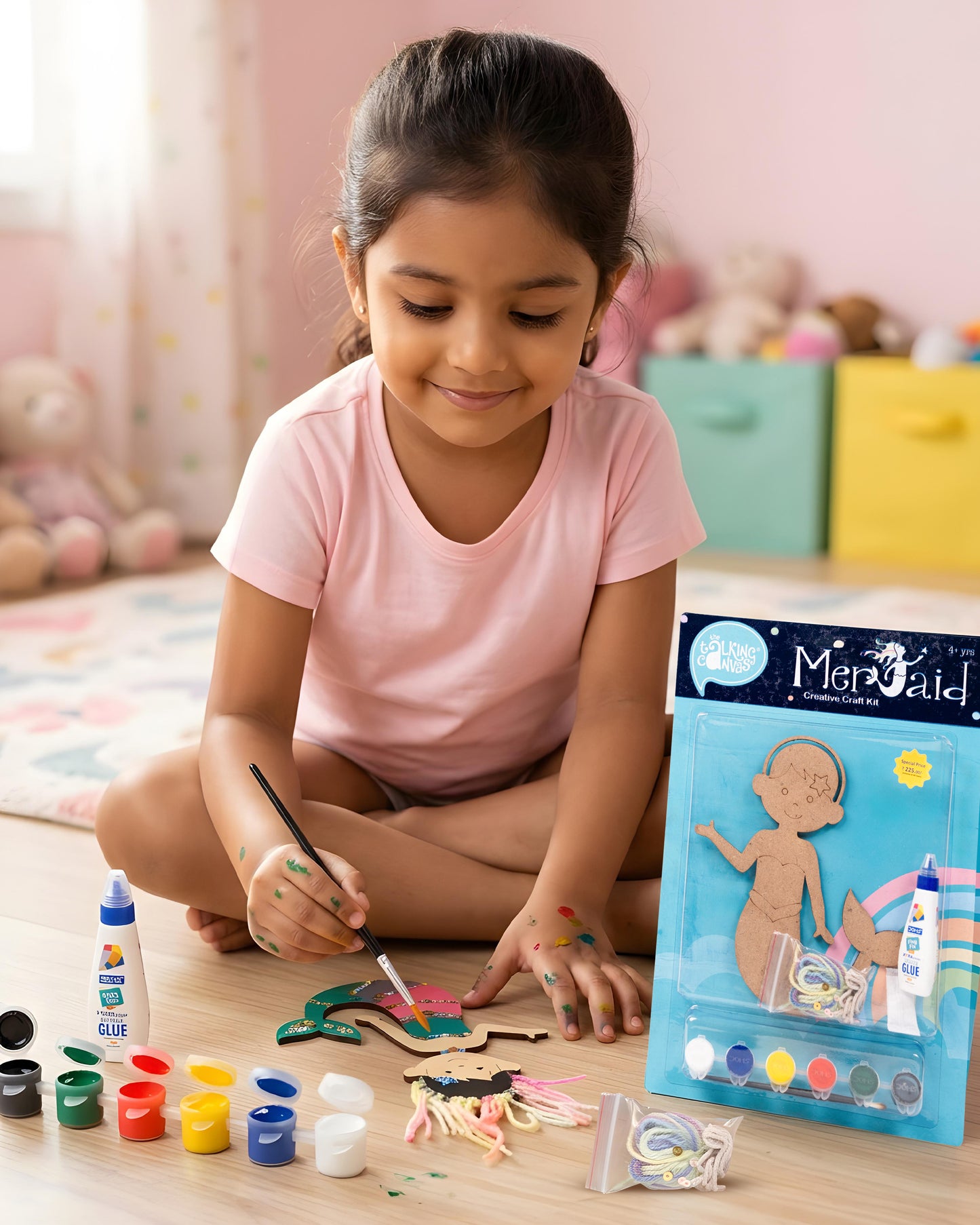 Child creating The Talking Canvas Mermaid Creative Craft Kit using paints, yarn, glue and sequins to decorate the MDF mermaid craft