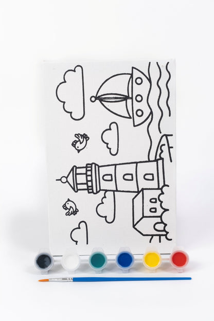 Lighthouse Ready-to-Paint Canvas Kit 6×9 with pre-printed lighthouse canvas, acrylic paint pots, paint brush and seaside artwork on white background.