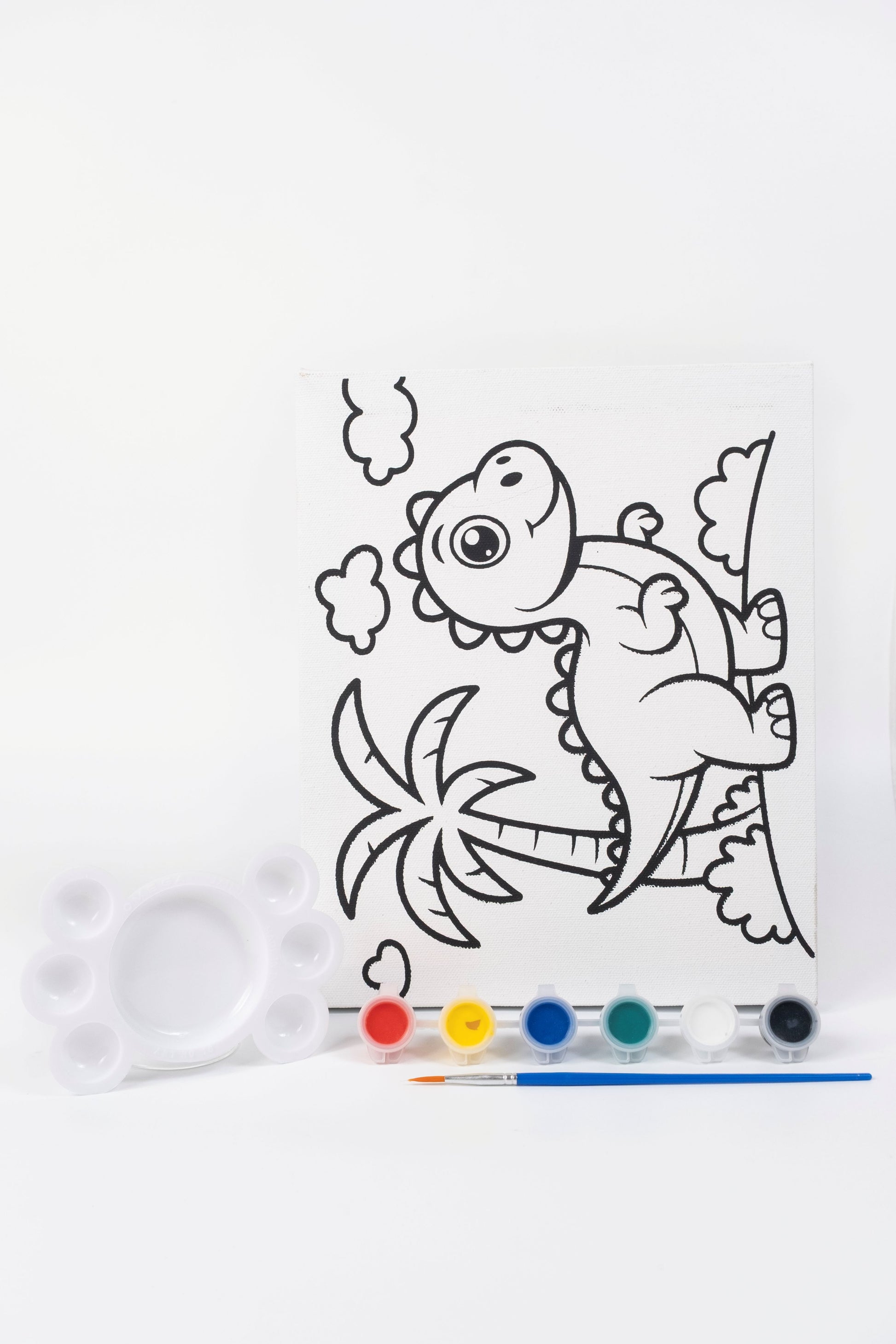 Dinosaur Ready-to-Paint Canvas Kit 8×10 with pre-printed dinosaur canvas, acrylic paint pots, paint brush and palette on white background.