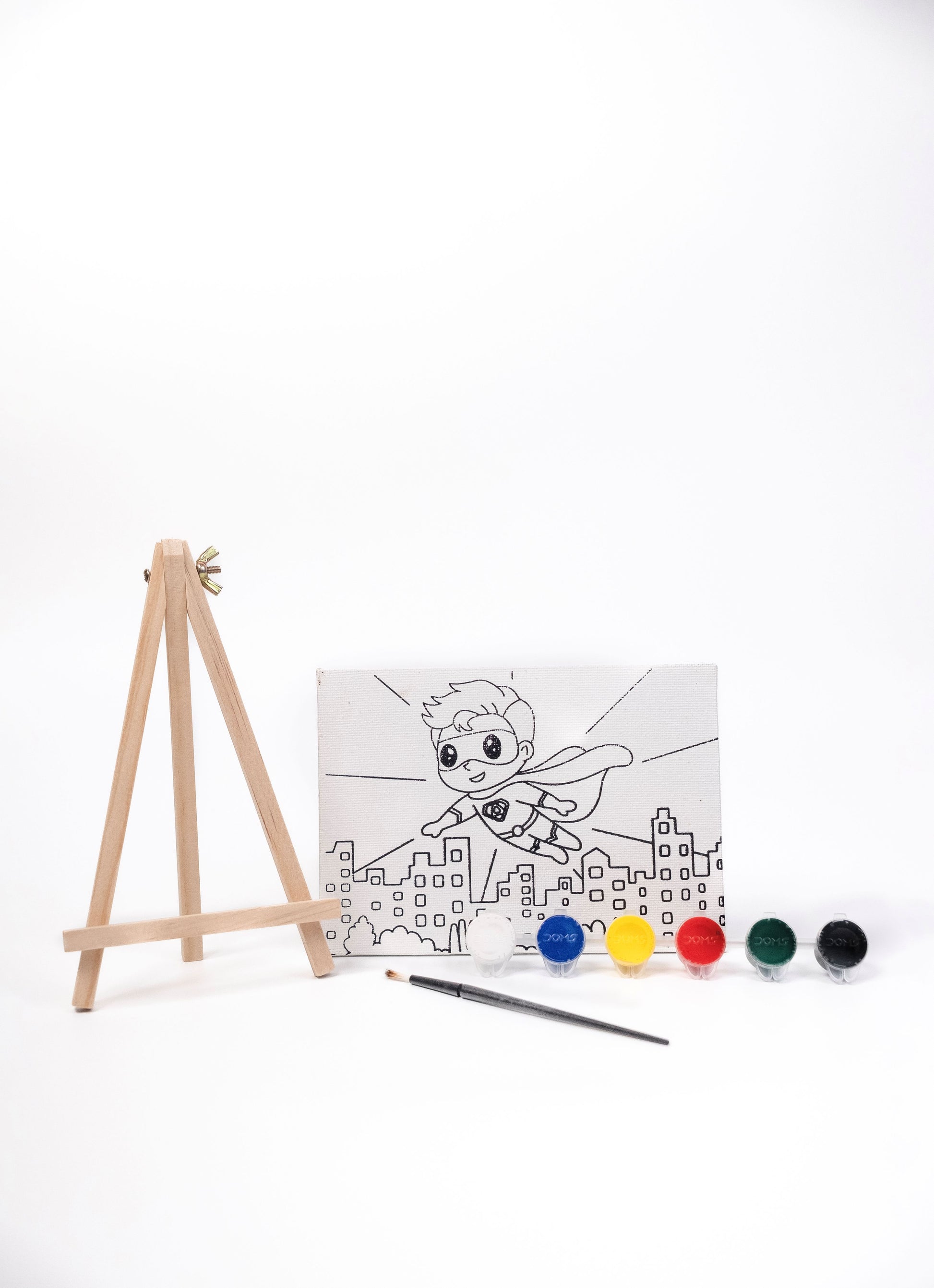 Superhero Canvas Painting Kit contents featuring a pre-printed superhero canvas, wooden easel, six acrylic paint pots and paint brush on a white background.