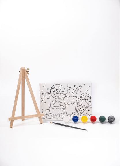 Sweet Treat Canvas Painting Kit contents featuring a pre-printed dessert canvas, wooden easel, six acrylic paint pots and paint brush on a white background.