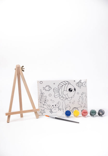 Ocean Canvas Painting Kit contents featuring a pre-printed underwater canvas, wooden easel, six acrylic paint pots and paint brush on a white background.