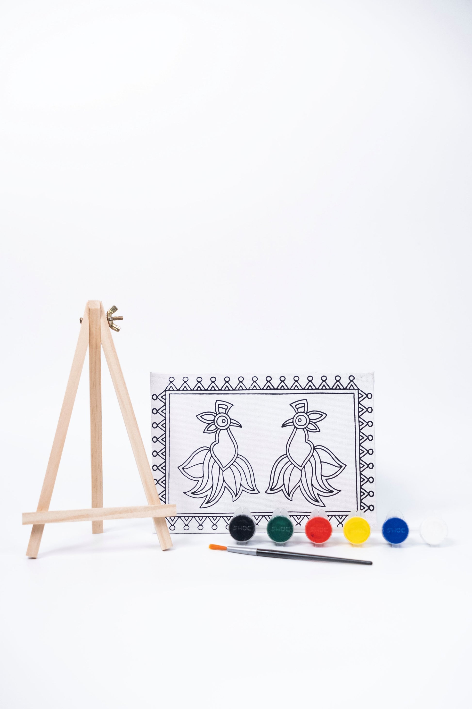 Contents of The Talking Canvas Madhubani Parrot Canvas Wall Art DIY Kit with outlined canvas, easel, brush and 6 acrylic paints.