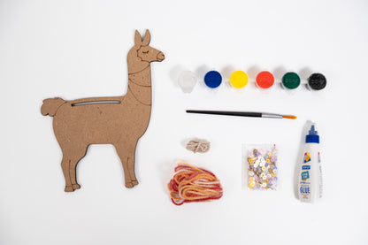 Contents of The Talking Canvas Llama Creative Craft Kit with MDF llama cutout, yarn, sequins, glue, brush and 6 acrylic paint pots.