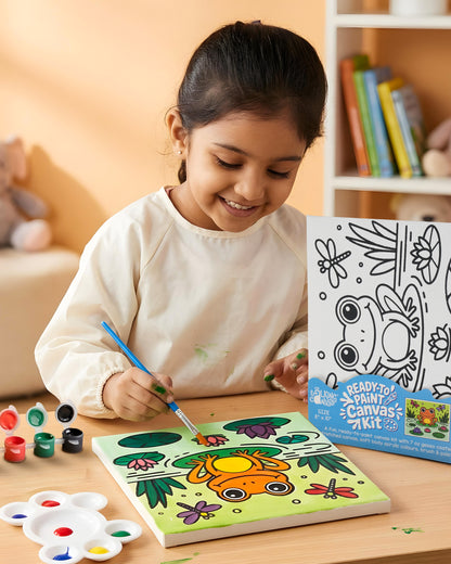 Child painting the Frog Ready-to-Paint Canvas Kit 8×10 using acrylic paints and brush with completed colourful frog pond artwork on canvas.