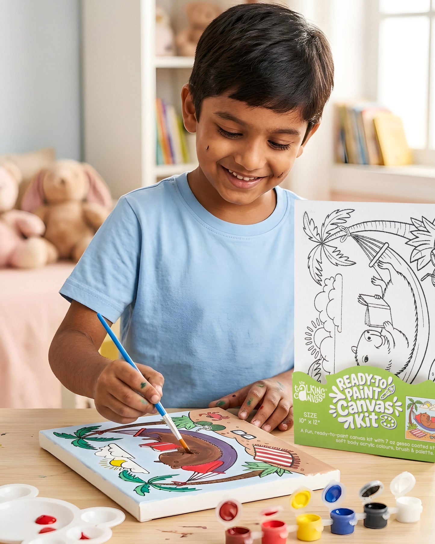 Child painting the Capybara Ready-to-Paint Canvas Kit featuring a tropical beach scene with a relaxing capybara in a hammock, palm trees and colourful acrylic paints.