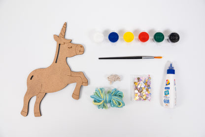 Contents of The Talking Canvas Unicorn Creative Craft Kit with MDF unicorn cutout, yarn, sequins, glue, brush and 6 acrylic paint pots.