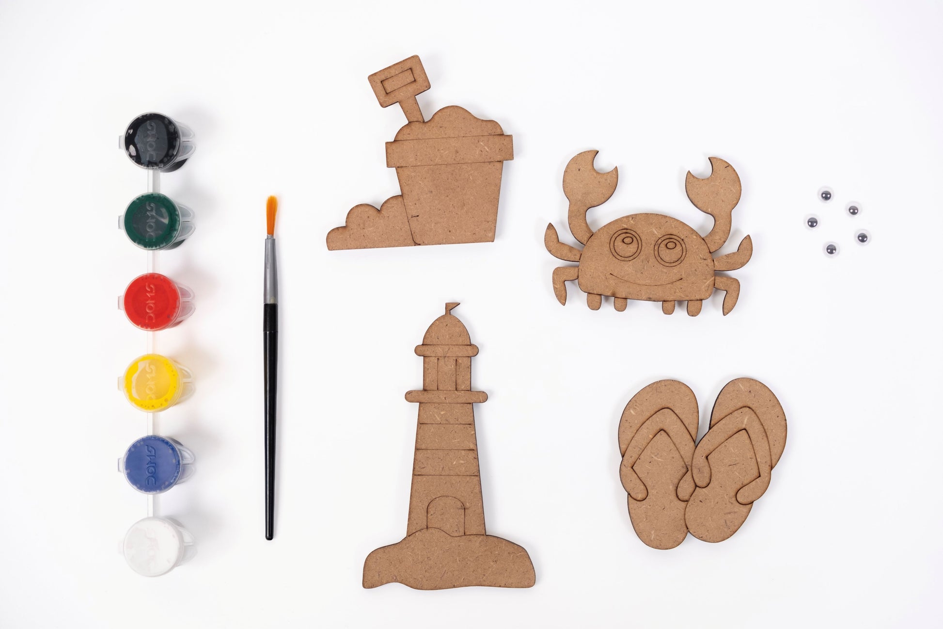 Beach Magnets DIY Kit contents with four MDF beach-themed magnet shapes, six acrylic paint pots, paint brush and five googly eyes on a white background.