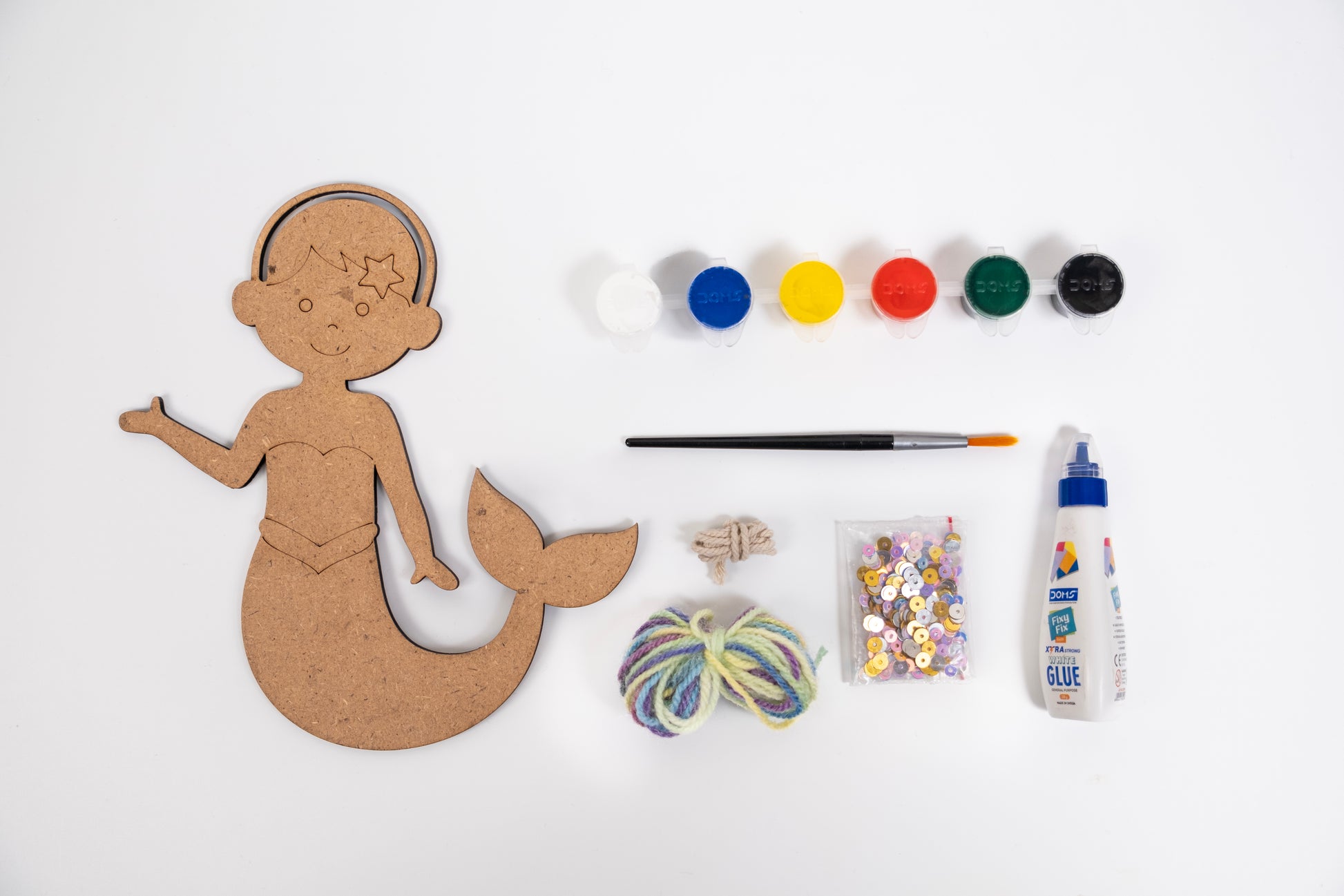 Contents of The Talking Canvas Mermaid Creative Craft Kit with MDF mermaid cutout, yarn, sequins, glue, brush and 6 acrylic paint pots.
