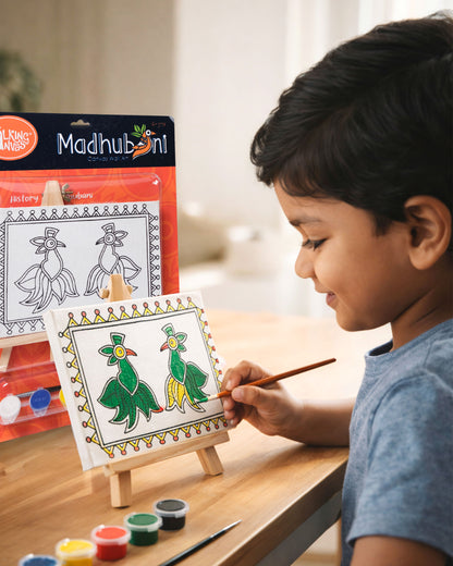 Child painting The Talking Canvas Madhubani Parrot Canvas Wall Art DIY Kit on easel using the included brush and acrylic paints.