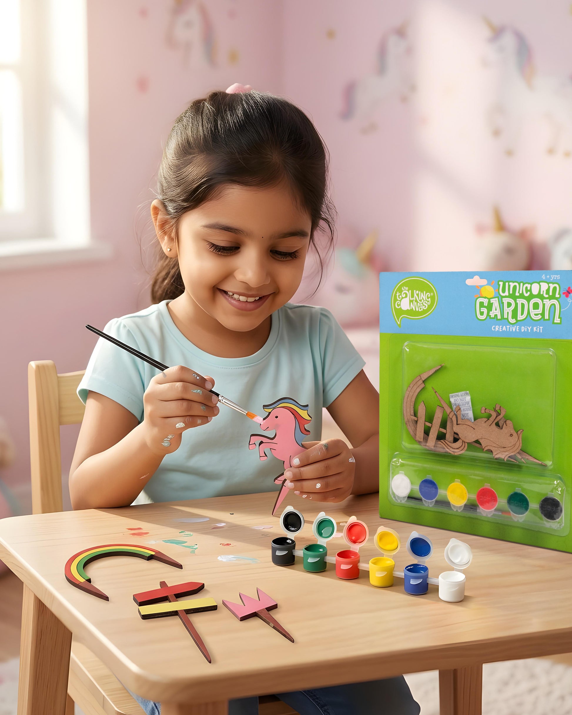 Child enjoying Creative DIY Kit – Unicorn Garden with painted unicorn garden, colourful artwork and DIY craft kit packaging.