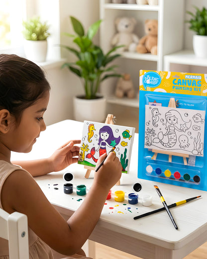 Child painting The Talking Canvas Mermaid Canvas Painting Kit on a wooden easel using the included paints and brush.