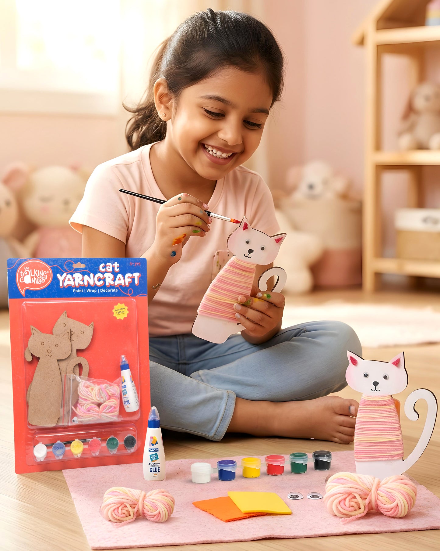 Child creating the Cat Yarn Craft Kit by painting, wrapping yarn around MDF cat cut-outs and decorating them with felt and googly eyes during a fun screen-free craft activity.