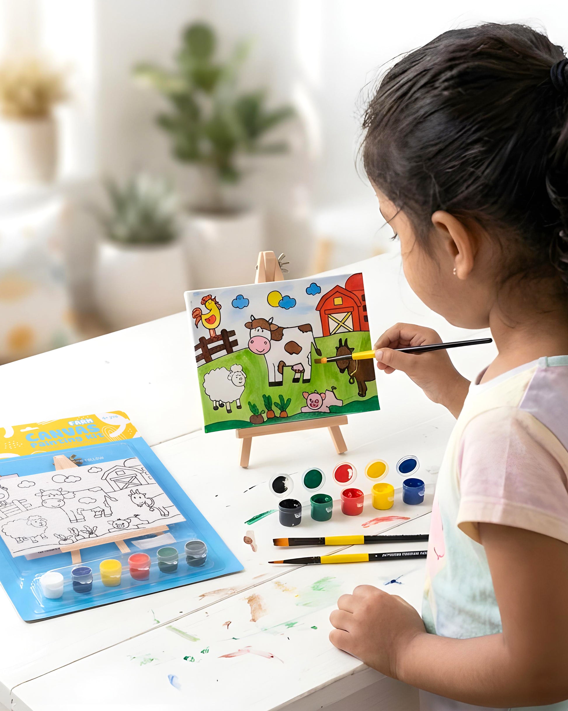 Child painting The Talking Canvas Farm Canvas Painting Kit on a wooden easel using the included paints and brush.