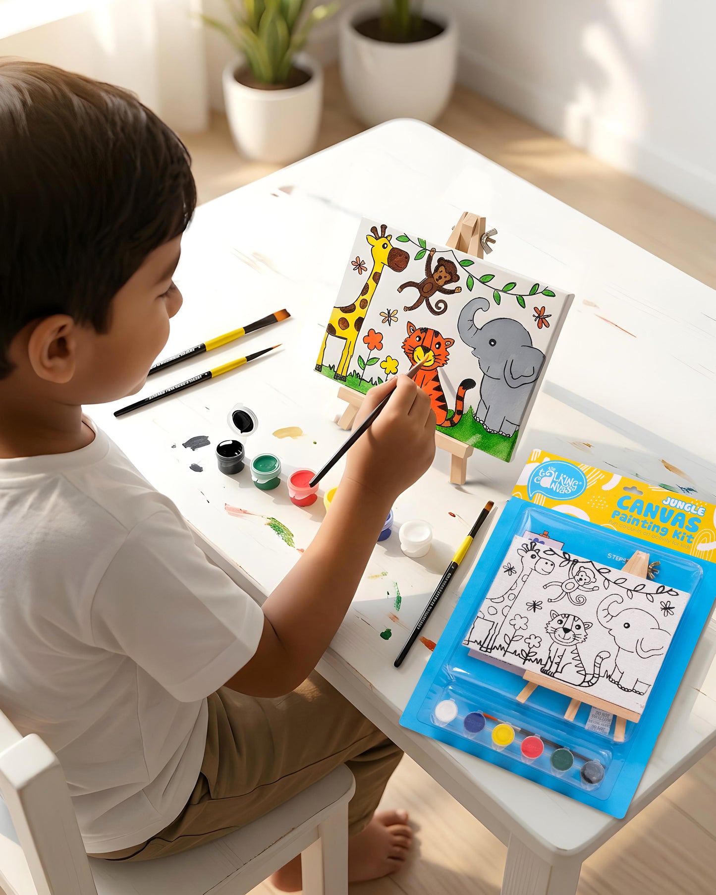 Child painting The Talking Canvas Jungle Canvas Painting Kit on a wooden easel using the included paints and brush.