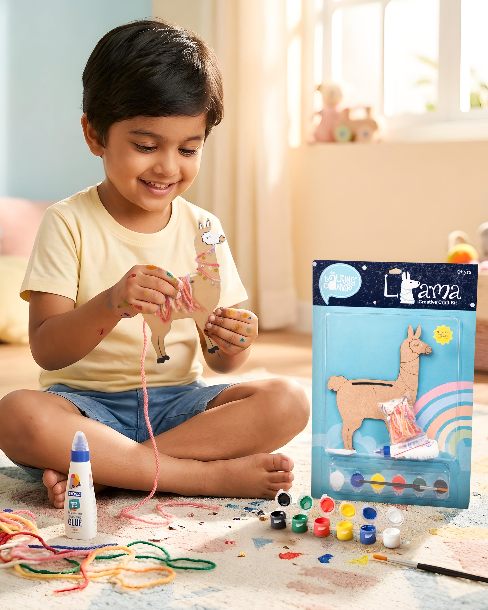 Child creating The Talking Canvas Llama Creative Craft Kit using yarn, glue, sequins and paints to decorate the MDF llama craft.