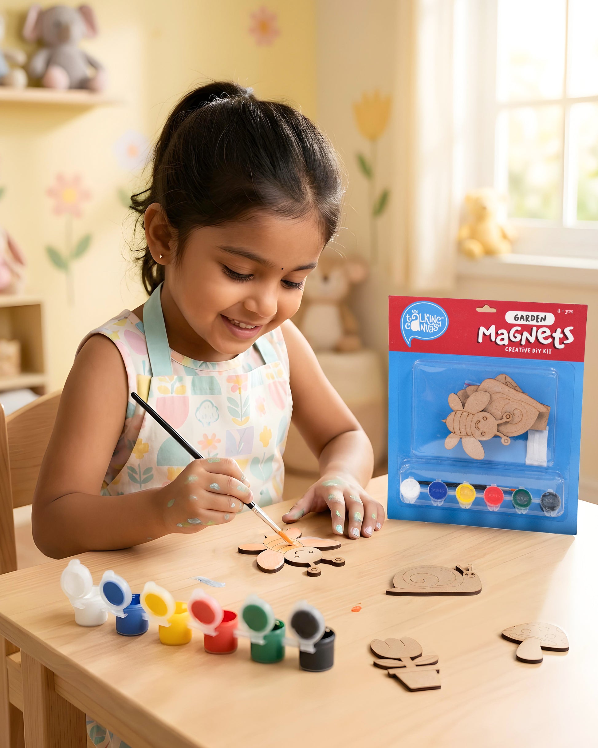 Child painting garden-themed wooden magnets from the Garden Magnets Creative DIY Kit using acrylic paints and brush during a fun screen-free craft activity.